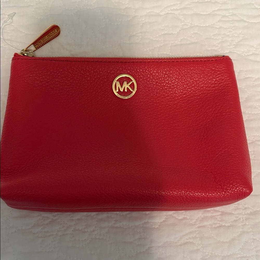Genuine Michael Kors pink cosmetic bag with gold zipper and branding.
